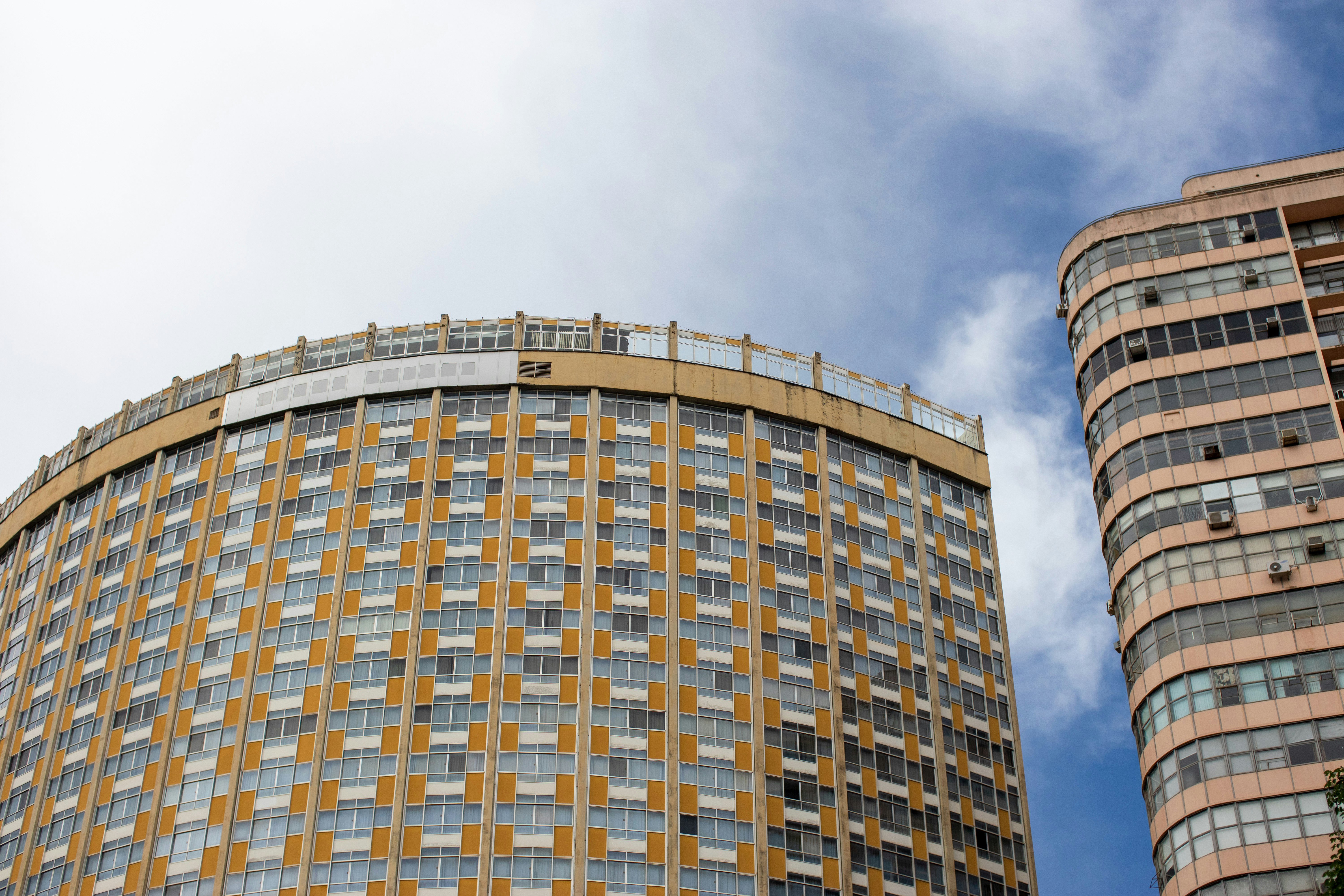 brown concrete building under white clouds during daytime